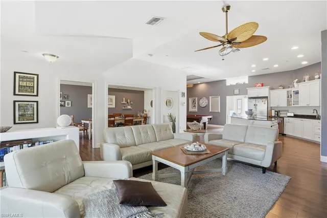 a living room with furniture kitchen view and a chandelier