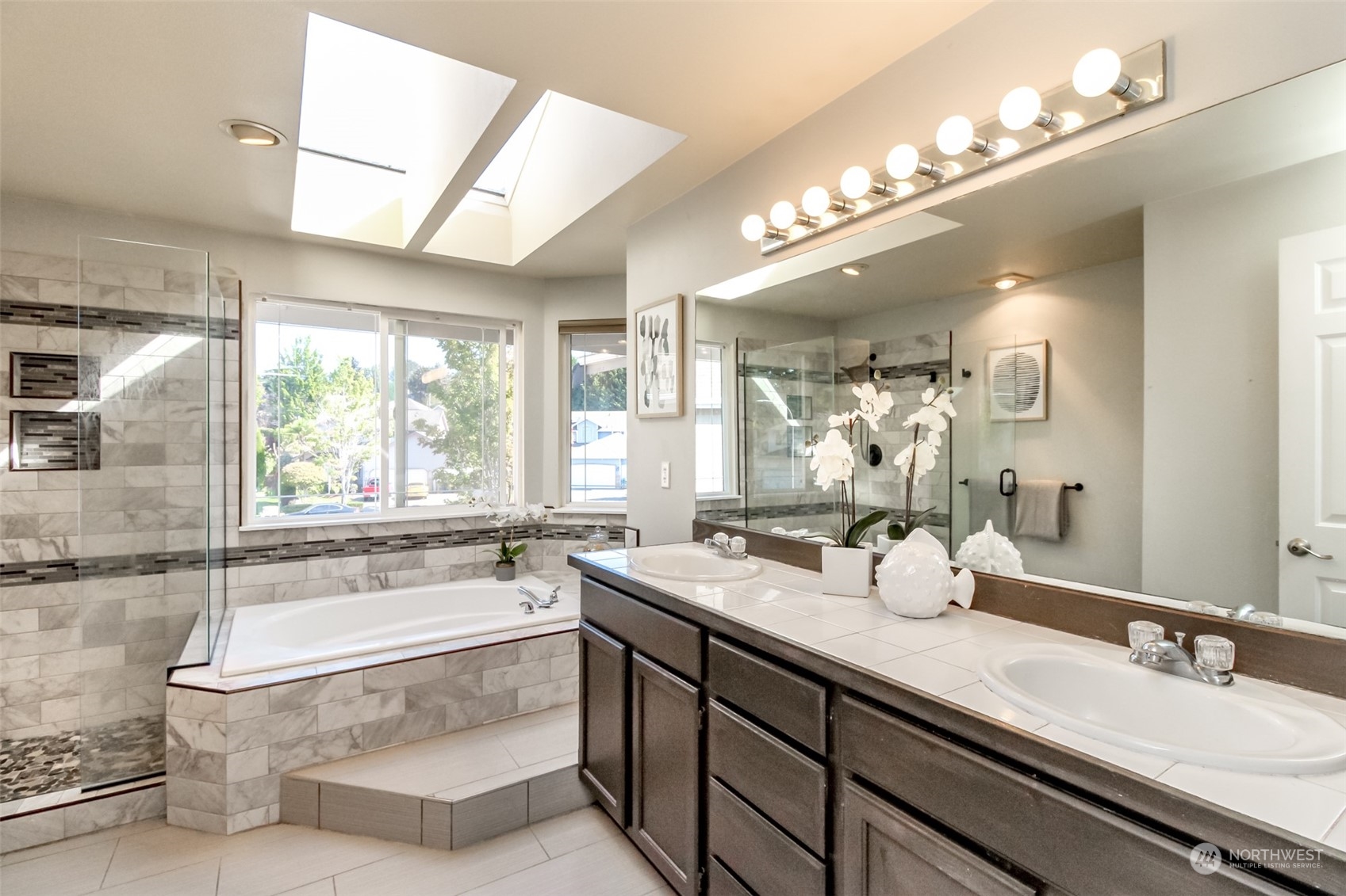 4609 Northeast 7th Place Renton, WA 98059 - Photo 18 of 30 a bathroom with a bathtub a double vanity sink and a large mirror