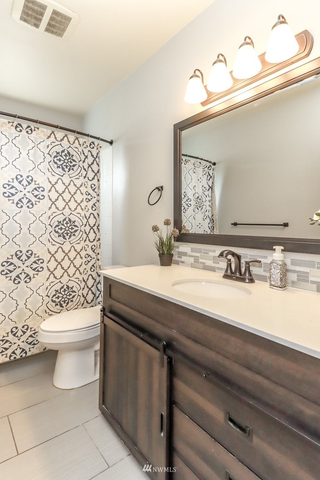 4609 Northeast 7th Place Renton, WA 98059 - Photo 21 of 30 a bathroom with a sink a toilet and a mirror