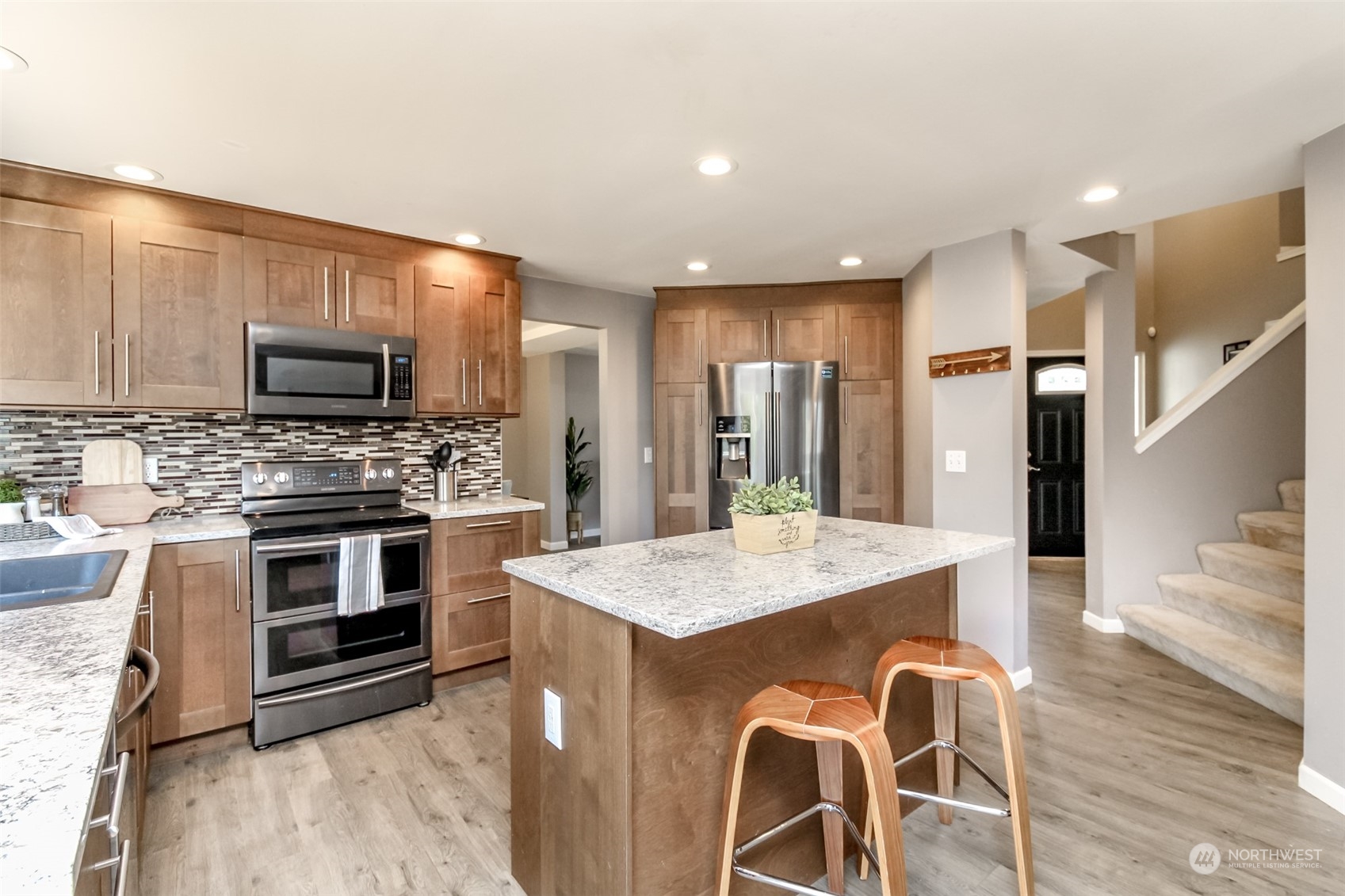 4609 Northeast 7th Place Renton, WA 98059 - Photo 3 of 30 a kitchen with stainless steel appliances granite countertop a stove refrigerator and a microwave