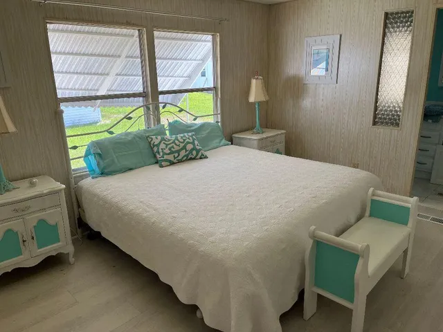 a bed sitting in a bedroom next to a window