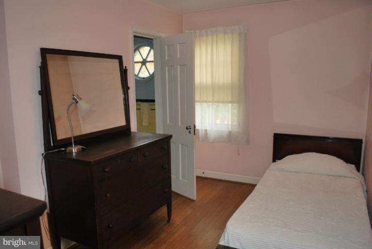 10163 Sutherland Road Silver Spring, MD 20901 - Photo 13 of 28 a living room with a bed furniture and a window