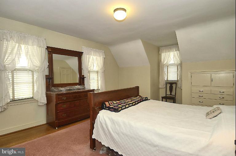 10163 Sutherland Road Silver Spring, MD 20901 - Photo 17 of 28 a bedroom with a bed and dresser with mirror