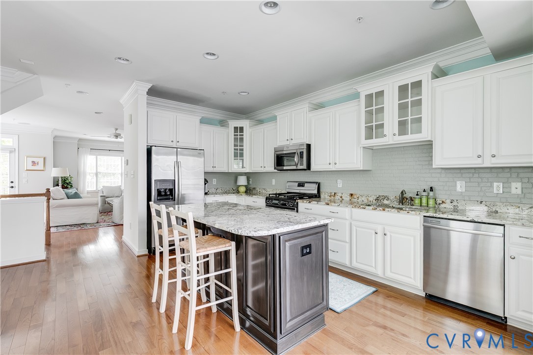 3900 Redbud Road Glen Allen, VA 23060 - Photo 15 of 37 a kitchen with stainless steel appliances granite countertop a stove top oven a refrigerator a sink dishwasher and white cabinets with wooden floor