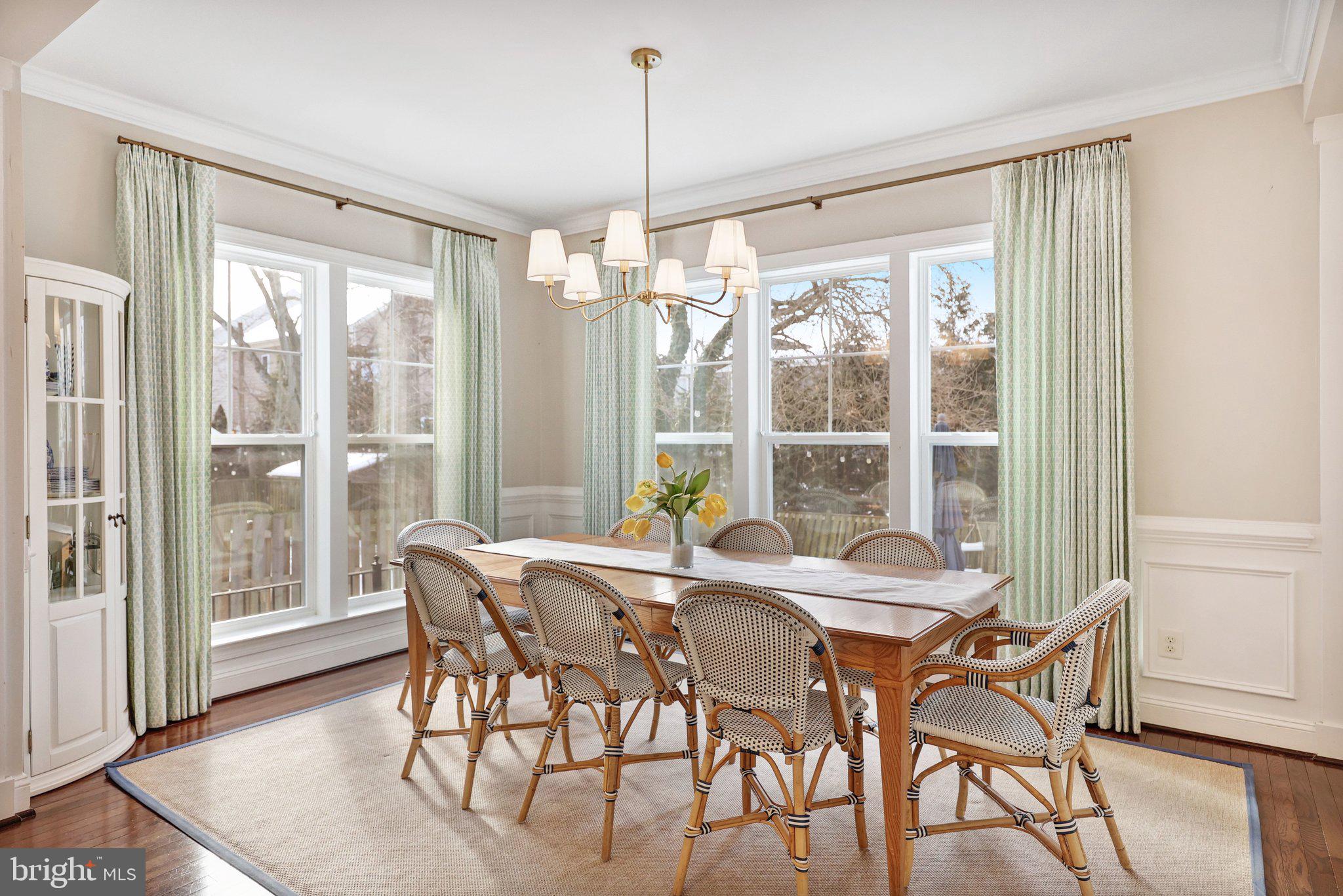 8028 Wellington Road Alexandria, VA 22308 - Photo 14 of 48 a view of a dining room with furniture large windows and wooden floor