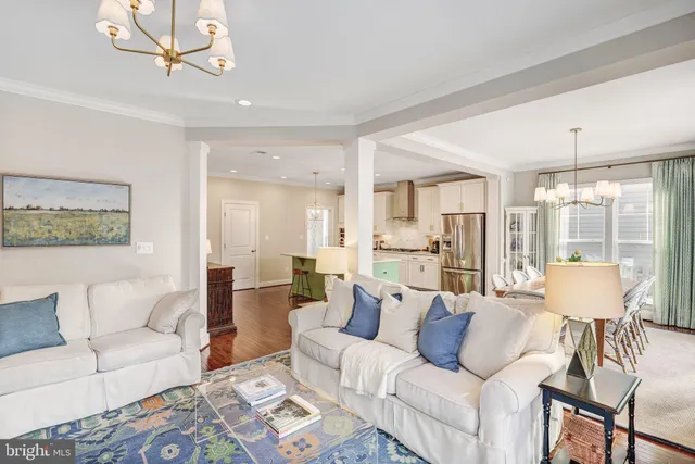 a living room with furniture a large window and a chandelier
