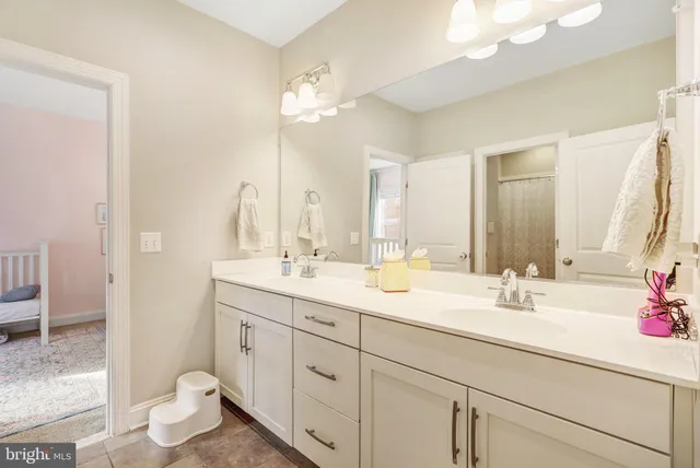 a bathroom with a double vanity sink mirror and toilet