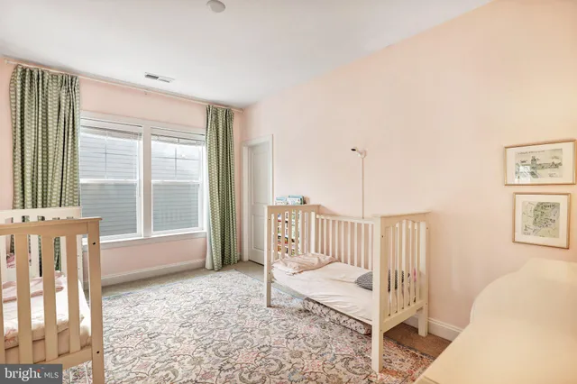 a view of a bedroom with wooden floor & a ceiling fan