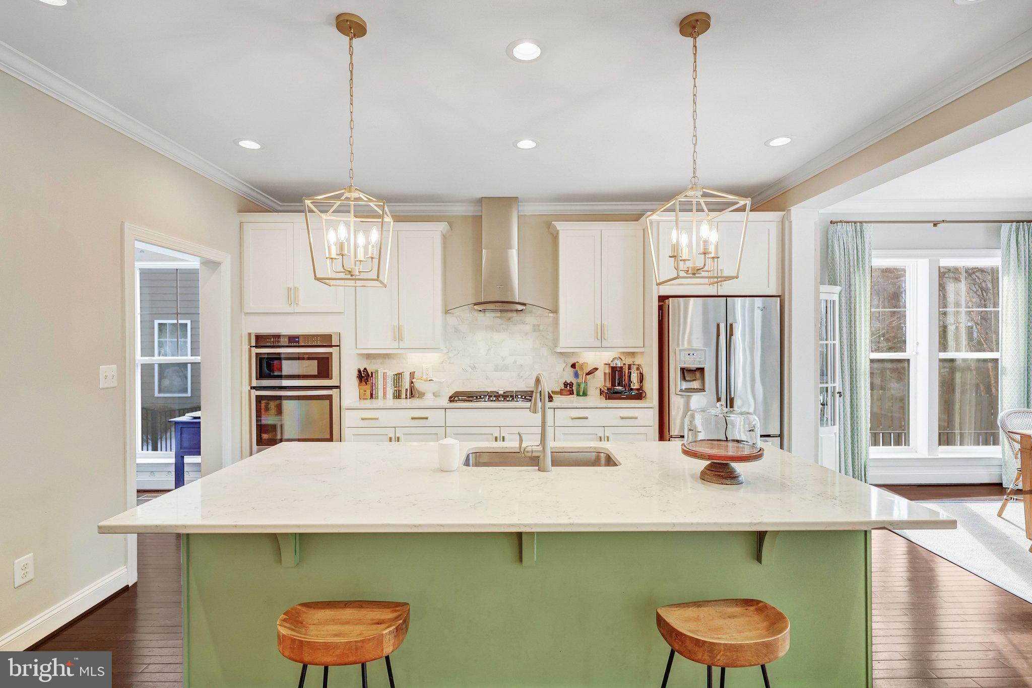 8028 Wellington Road Alexandria, VA 22308 - Photo 10 of 48 a kitchen with kitchen island a sink a counter space appliances and cabinets