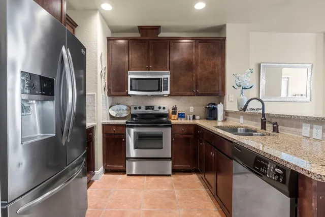 a kitchen with granite countertop a sink a stove and cabinets