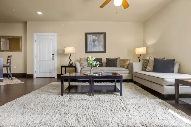 a living room with furniture and a dining table with wooden floor