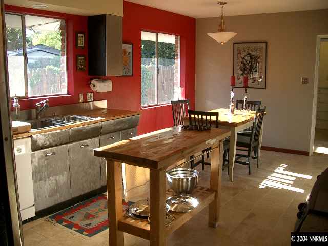803 Whitaker Drive Reno, NV 89503 - Photo 3 of 4 a kitchen with stainless steel appliances granite countertop a stove a sink and a dining table with granite countertop chairs