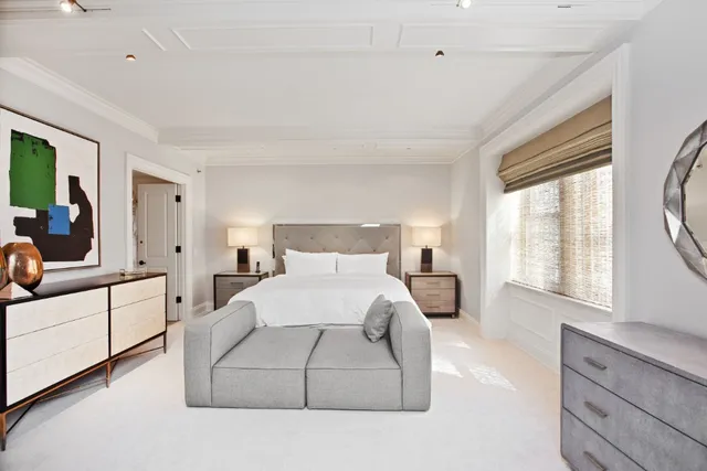 a large white kitchen with a lot of counter space and wooden floor