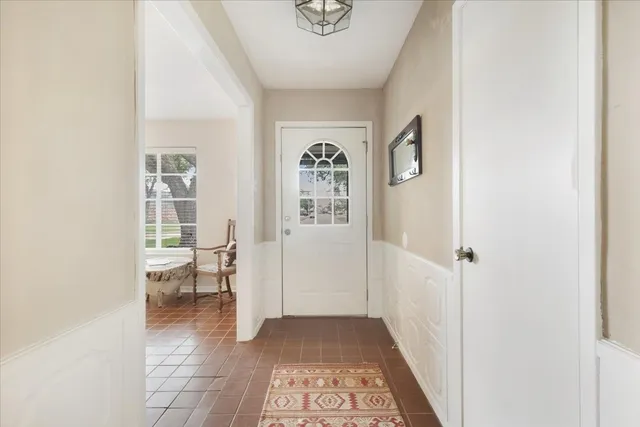a view of a hallway to a livingroom with furniture and window