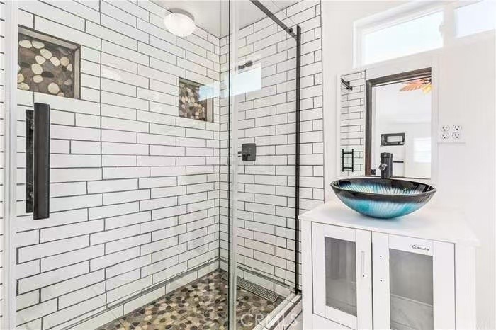 1105 East Walnut Avenue Fullerton, CA 92831 - Photo 18 of 22 a bathroom with a sink a mirror and shower