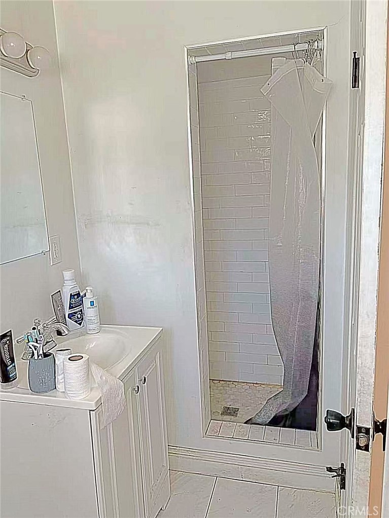 1105 East Walnut Avenue Fullerton, CA 92831 - Photo 10 of 22 a bathroom with a sink a mirror and shower