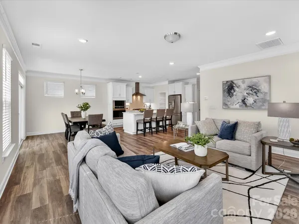 a living room with furniture kitchen view and a window