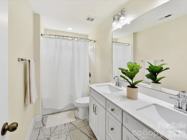 a bathroom with a granite countertop sink a toilet and shower