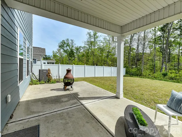 a roof deck with table and chairs and wooden fence