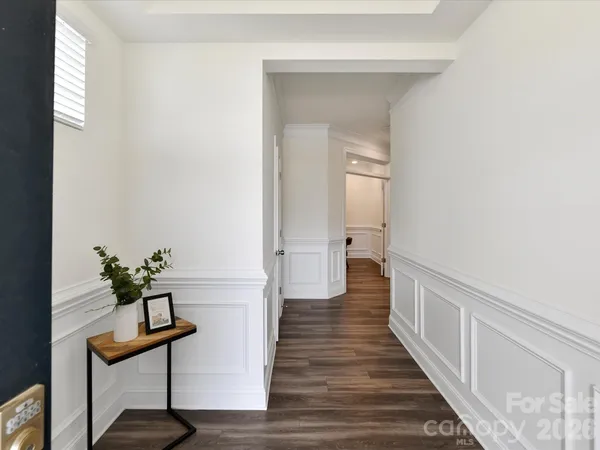 a view of a hallway with wooden floor and staircase