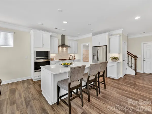 a kitchen with stainless steel appliances a microwave a stove a table and chairs