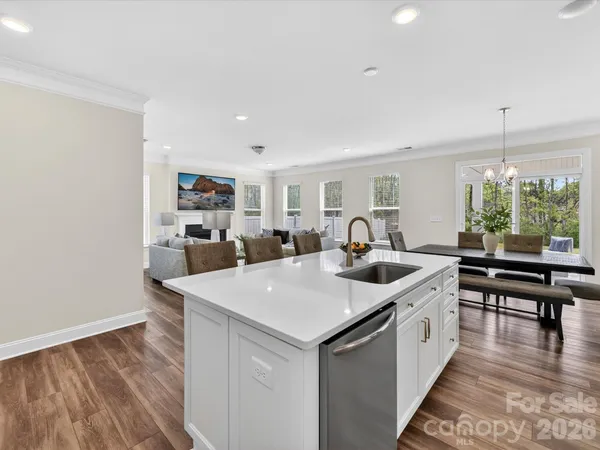 a kitchen with sink and view of living room