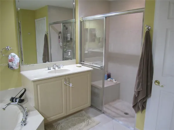 a bathroom with a sink vanity mirror and a bathtub