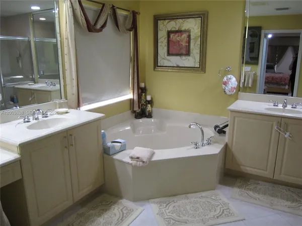 a bathroom with a tub a sink and a mirror