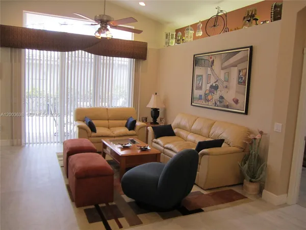 a living room with furniture a large window and a chandelier