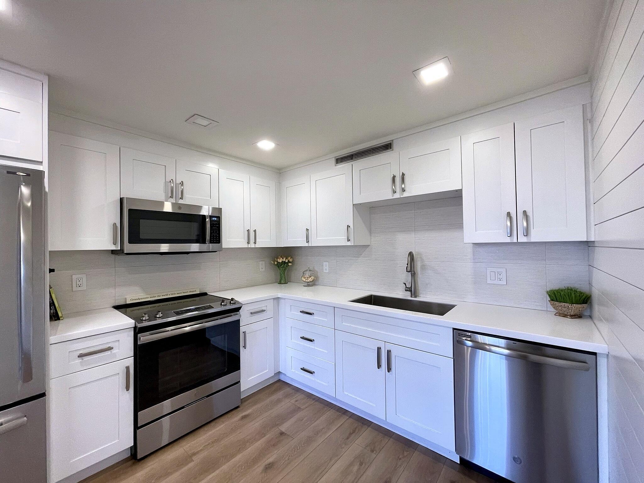1030 Rexford B Boca Raton, FL 33434 - Photo 8 of 27 a kitchen with sink a microwave and cabinets