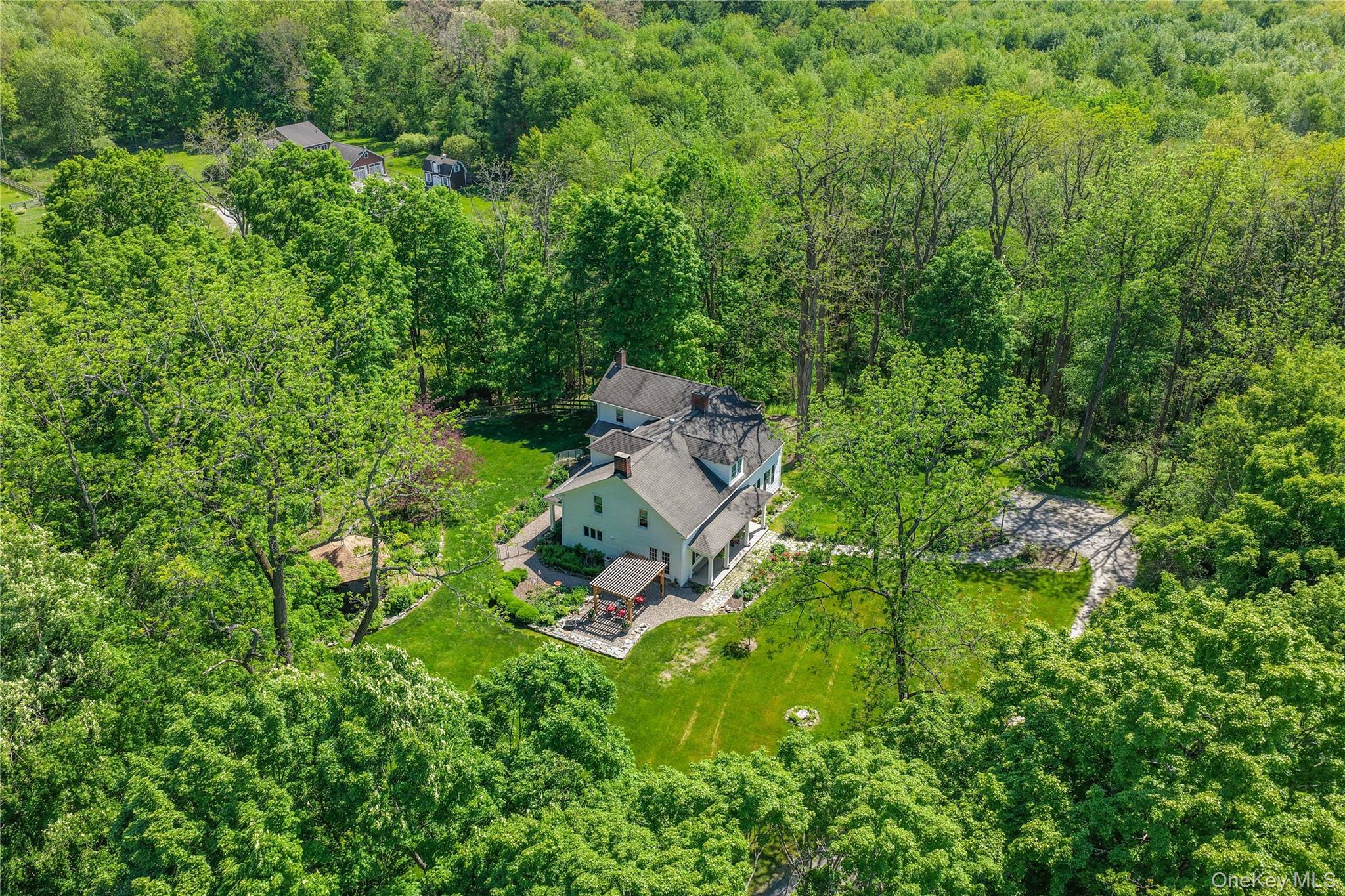 an aerial view of residential house with outdoor space and trees all around