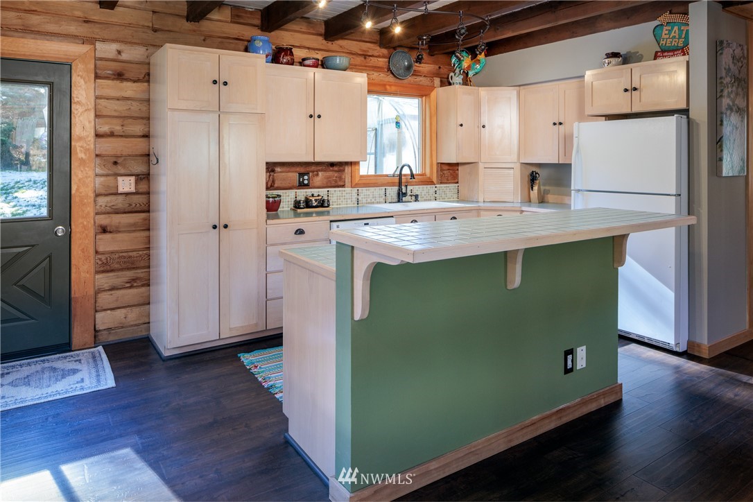 230 Eliza Road Lopez Island, WA 98261 - Photo 7 of 26 a kitchen with kitchen island a sink a refrigerator and wooden floor