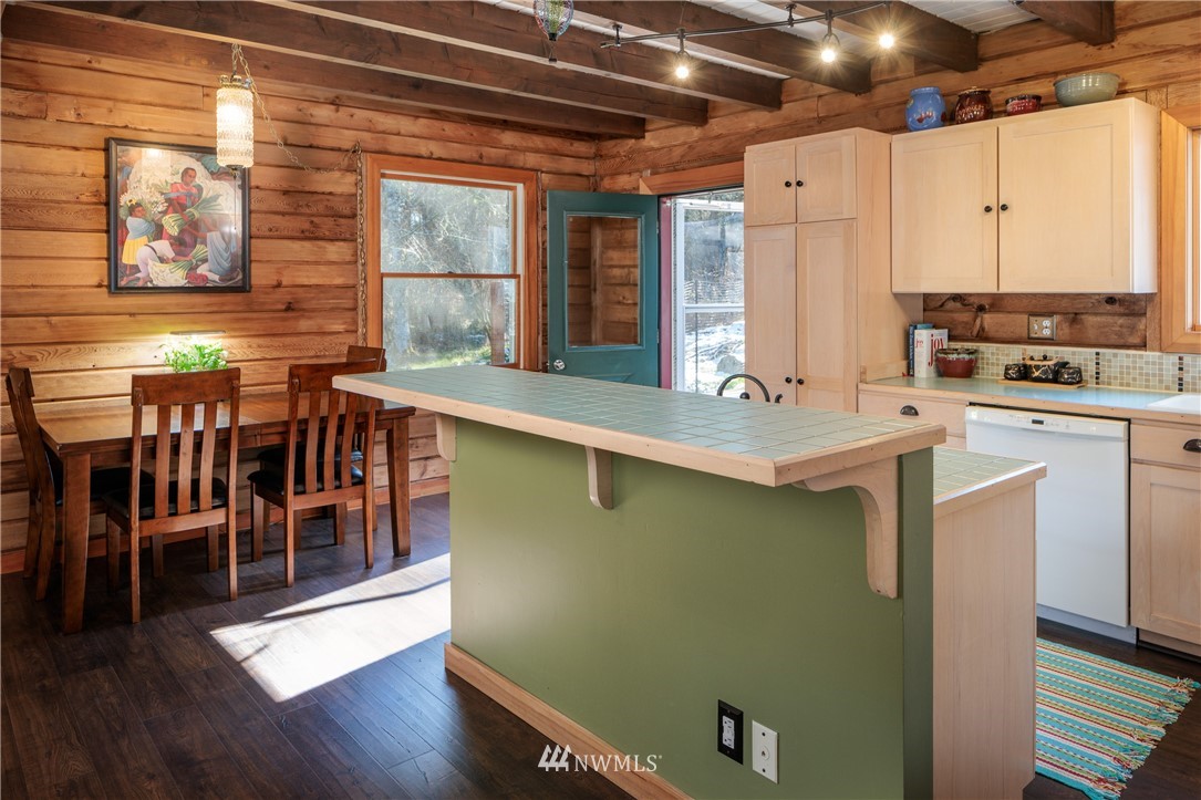 230 Eliza Road Lopez Island, WA 98261 - Photo 8 of 26 a kitchen with stainless steel appliances granite countertop a sink window and wooden floor