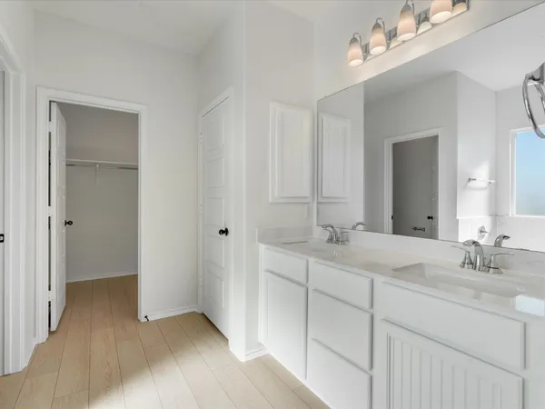 a bathroom with double sink and a mirror