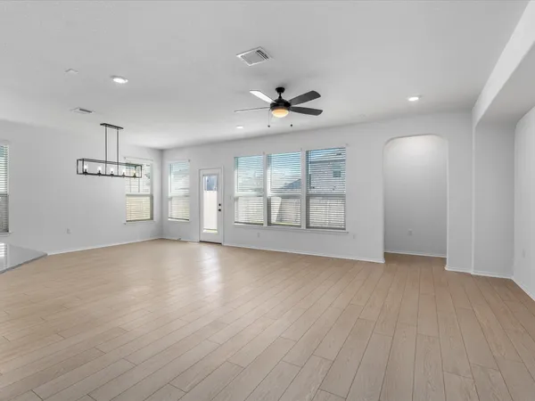 a view of an empty room with a window and wooden floor