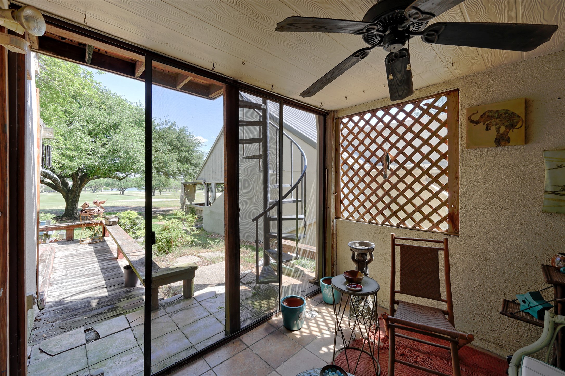 34 April Hill Conroe, TX 77356 - Photo 21 of 33 The screened in porch offers views of the golf course and lake. A ceiling fan for extra air flow during warmer months. The spiral staircase leads to a second floor loft area.