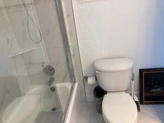 400 Wilma Circle, Unit 208 Riviera Beach, FL 33404 - Photo 13 of 28 a white toilet sitting next to a bath tub and a shower