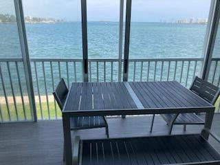 400 Wilma Circle, Unit 208 Riviera Beach, FL 33404 - Photo 3 of 28 a view of a wooden deck with a table and chairs