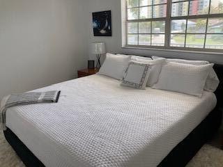 400 Wilma Circle, Unit 208 Riviera Beach, FL 33404 - Photo 10 of 28 a bedroom with a bed and a window