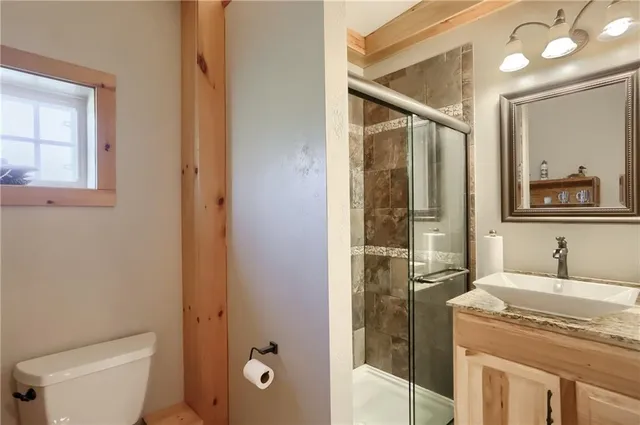 a bathroom with a granite countertop sink toilet and shower