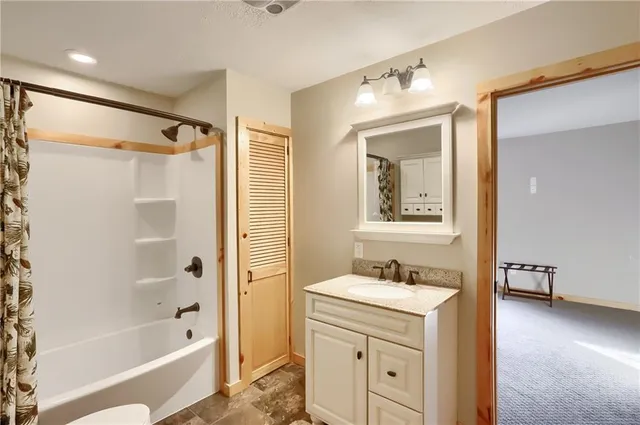 a bathroom with a bathtub shower sink and mirror