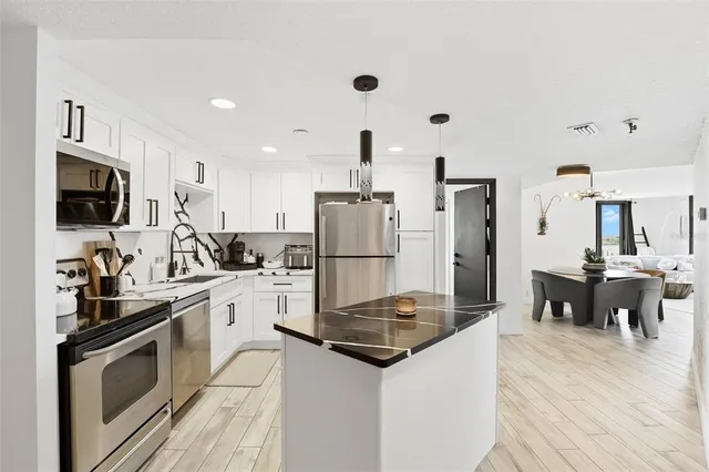a kitchen with a sink stainless steel appliances and white cabinets