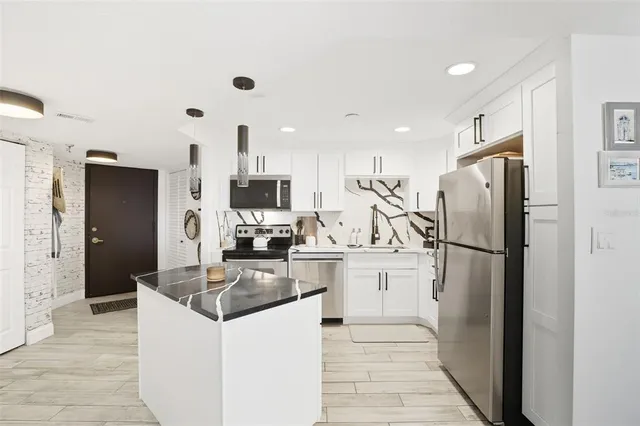 a kitchen with stainless steel appliances granite countertop a refrigerator stove microwave and sink