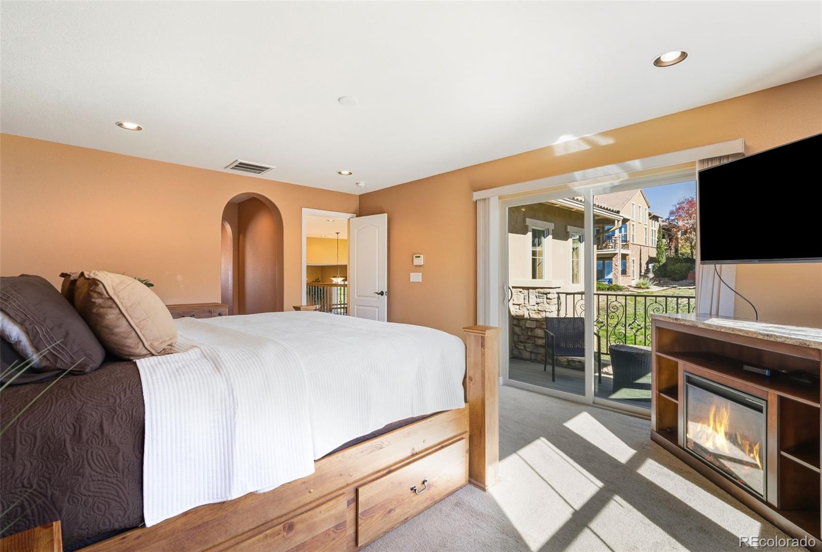9472 Sori Lane Highlands Ranch, CO 80126 - Photo 18 of 43 a bedroom with a bed and a flat screen tv