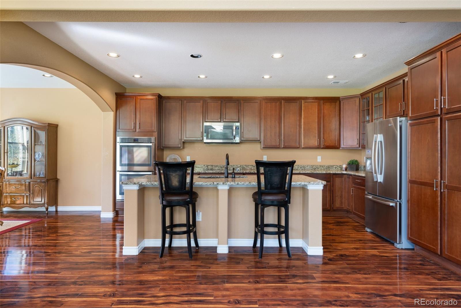 9472 Sori Lane Highlands Ranch, CO 80126 - Photo 5 of 43 a kitchen with stainless steel appliances granite countertop a refrigerator and a stove top oven