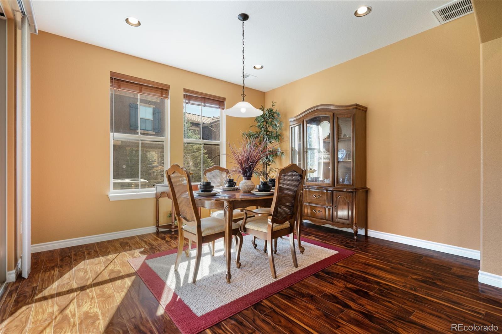 9472 Sori Lane Highlands Ranch, CO 80126 - Photo 10 of 43 a dining room with furniture a chandelier and wooden floor