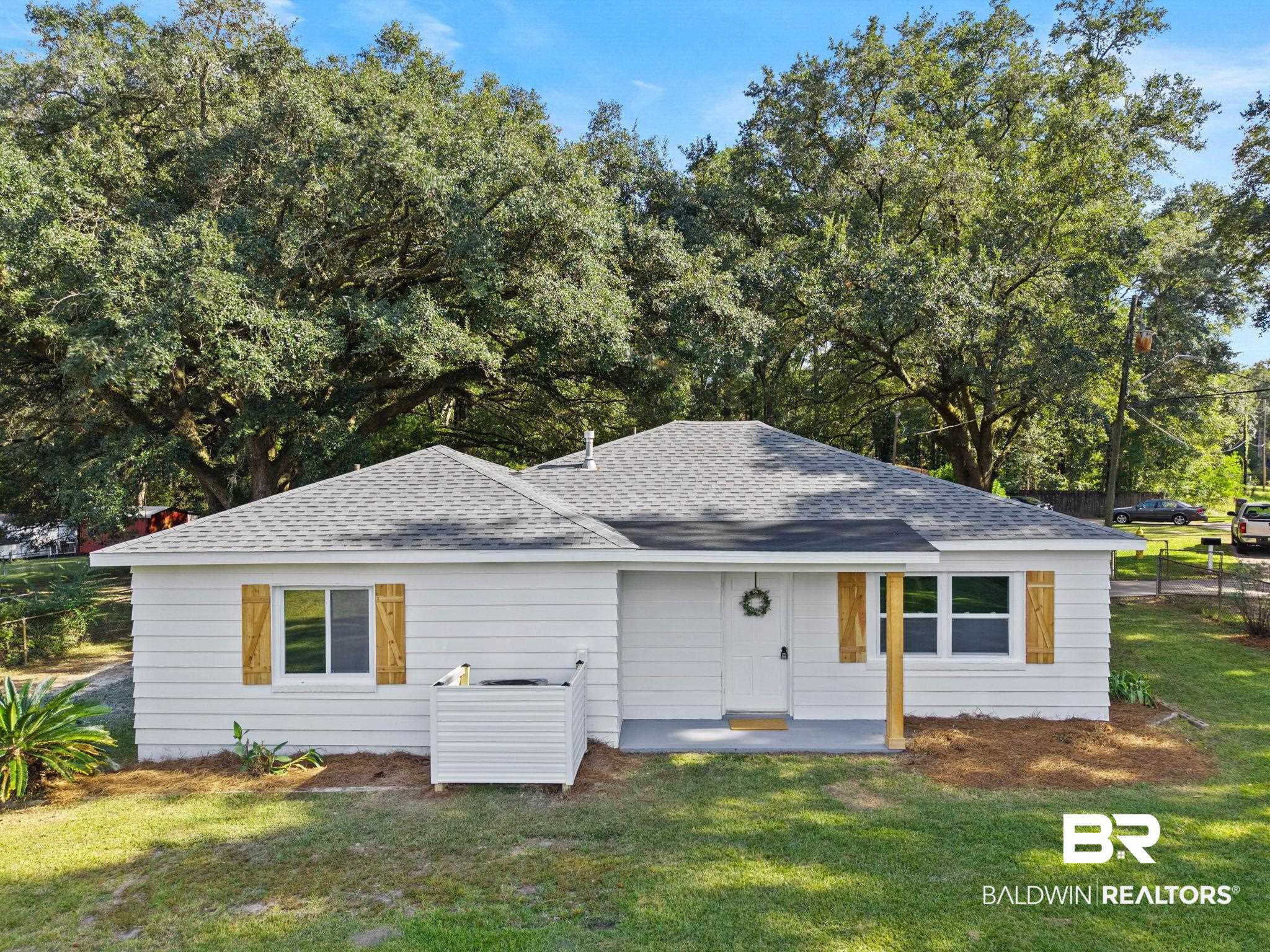 618 Pine Street Saraland, AL 36571 - Photo 1 of 41 View of front of house featuring roof with shingles, a front lawn, and view of wooded area