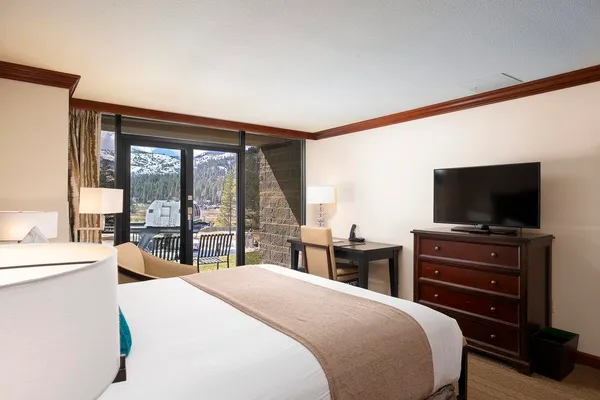 a bedroom with a bed and a flat tv screen on dresser