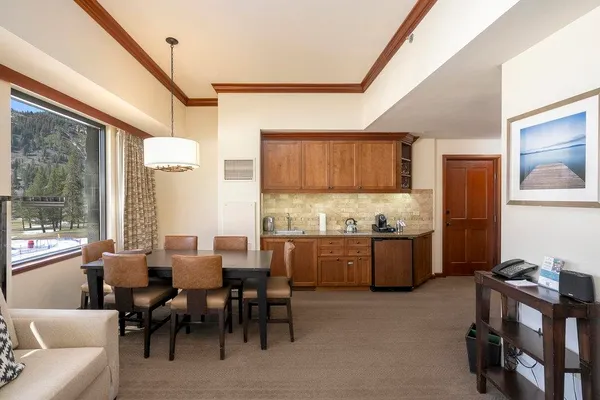 a kitchen with stainless steel appliances kitchen island granite countertop a table chairs in it and wooden floors