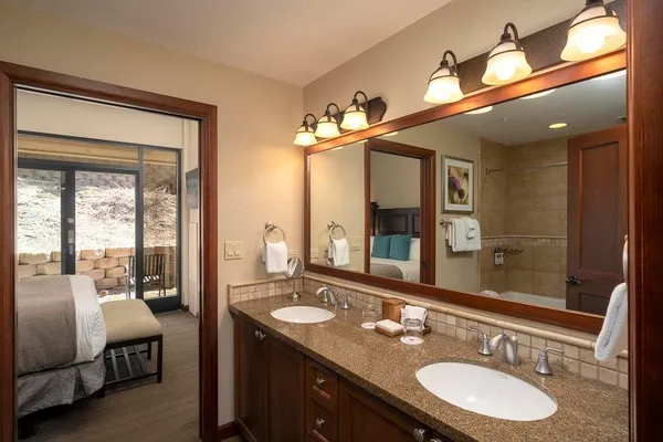 a bathroom with a granite countertop double vanity and a mirror